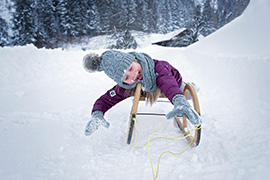 Kinderspass auf der Rodel im Winter